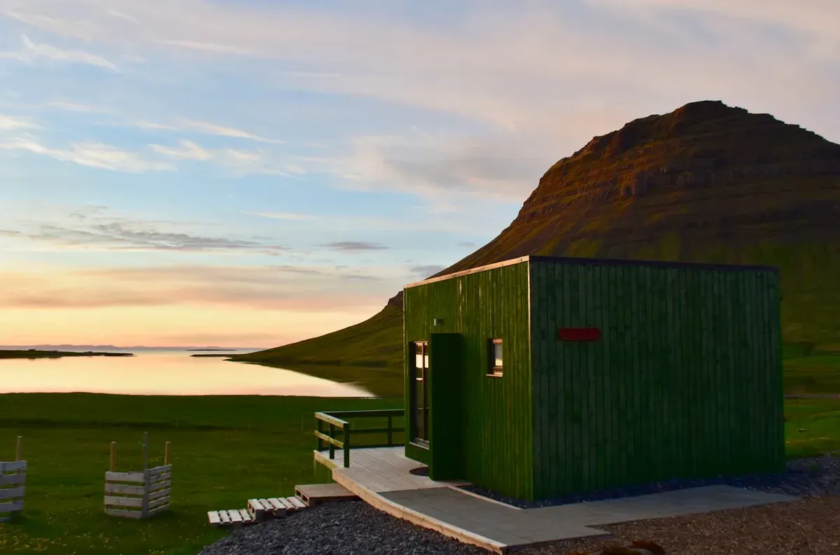 Green cabin at twilight, serene Icelandic landscape